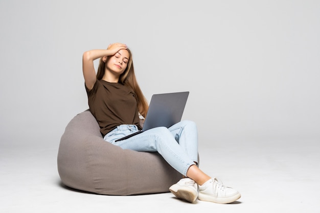 흰색 벽에 고립 된 작업에 필사적으로 컴퓨터 노트북을 사용하는 우울 하 고 좌절 여자. 우울증