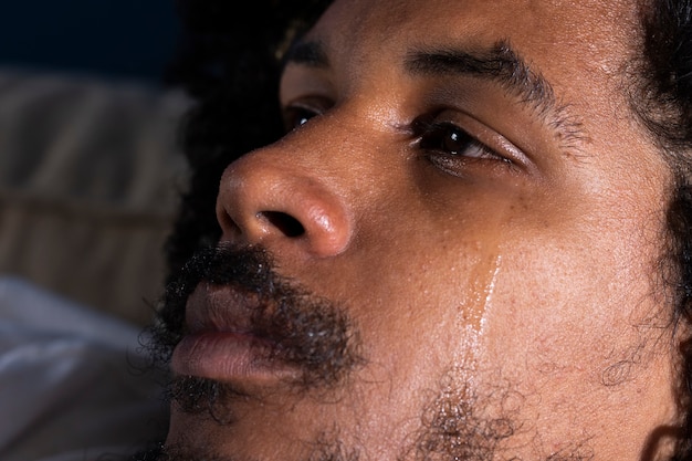 Depressed man crying side view