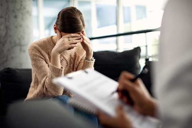 Depressed woman having psychotherapy session at doctor's office