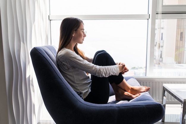 La donna depressa si siede sulla sedia di casa