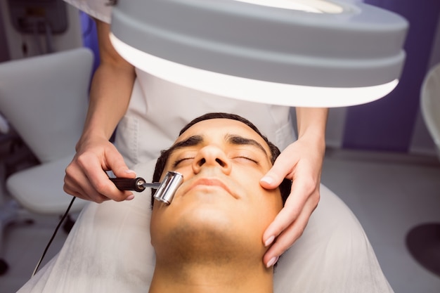 Dermatologist performing laser hair removal on patient