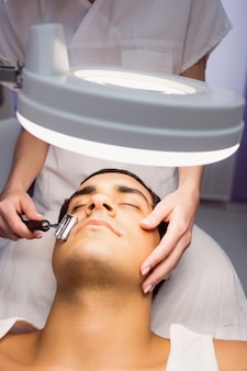Dermatologist performing laser hair removal on patient