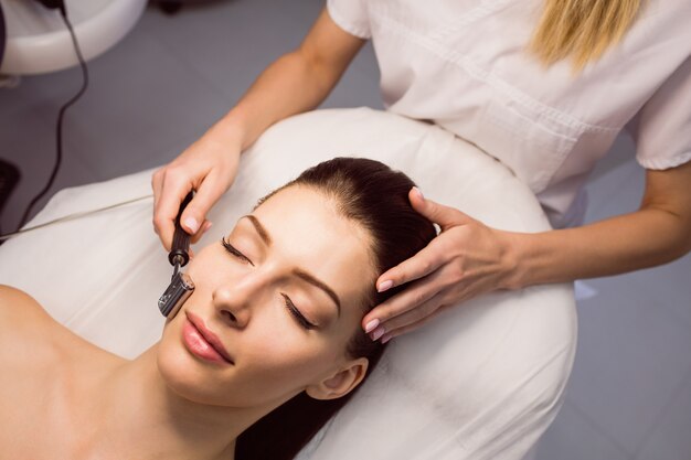 Dermatologist performing laser hair removal on patient