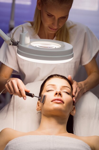 Dermatologist performing laser hair removal on patient