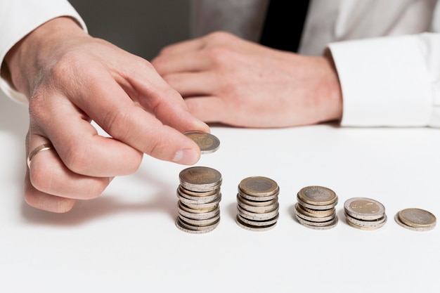 Descending piles of coins and man