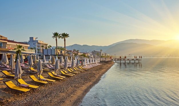 Foto gratuita spiaggia deserta al sole del mattino la spiaggia all'alba lettini vuoti spiaggia senza persone marmaris