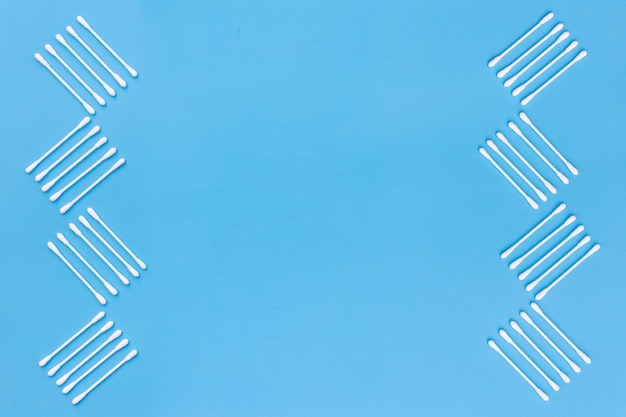 Free photo design made with cotton swabs on the side of blue background