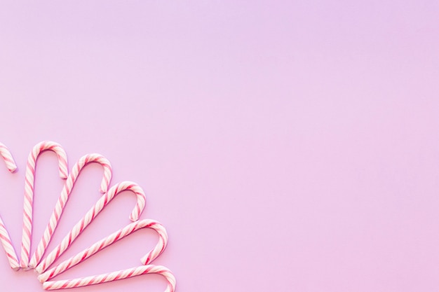 Free photo design made with xmas candy cane on the pink background corner