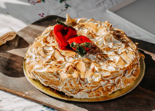 designed cake with strawberries on top yummy delicious on gold colored desk brown