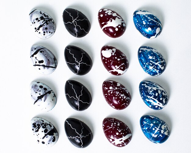 Разработанные шоколадные конфеты изолированы красочным художественным шоколадом на белой поверхности