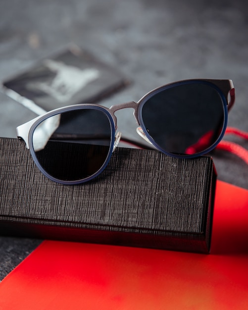 Designed sunglasses on the red book and grey surface