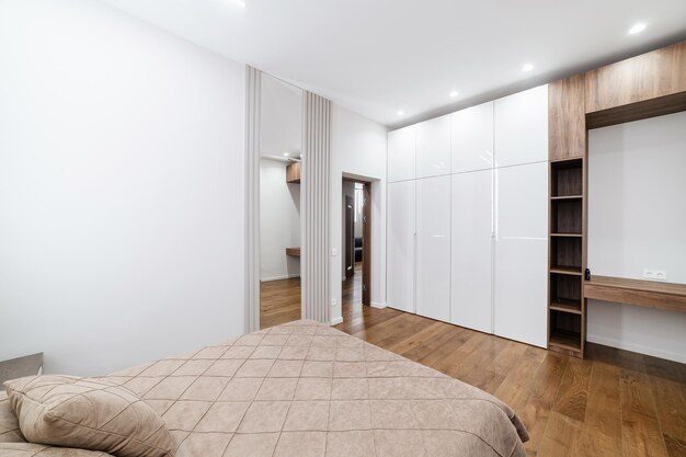 Дизайнерский большой, белый шкаф в комнате для одежды.