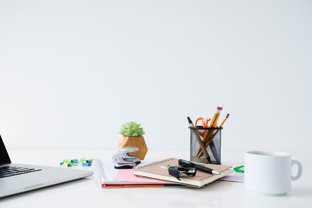 Desk arrangement with laptop and notebooks