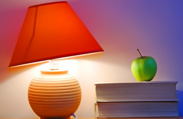 Free photo desk lamp and an apple