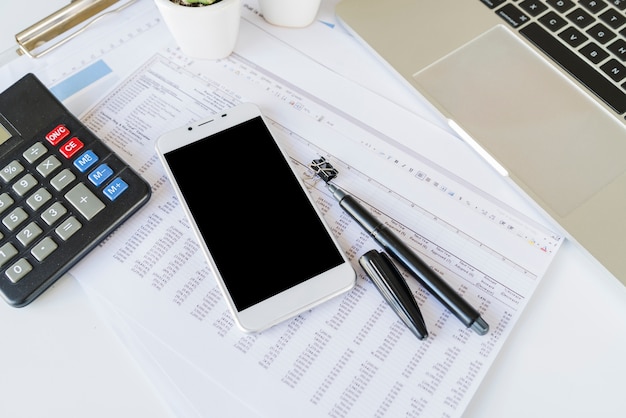 Desk of office accountant with calculator and smartphone