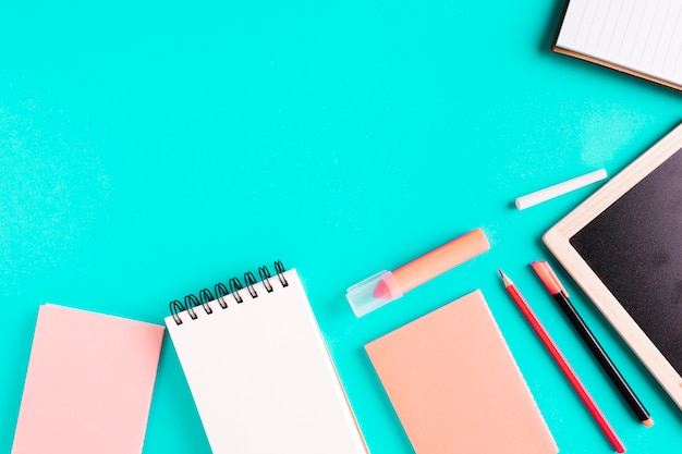 Desk and school supplies on colored surface