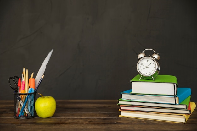 Desk with books stationery and clocks