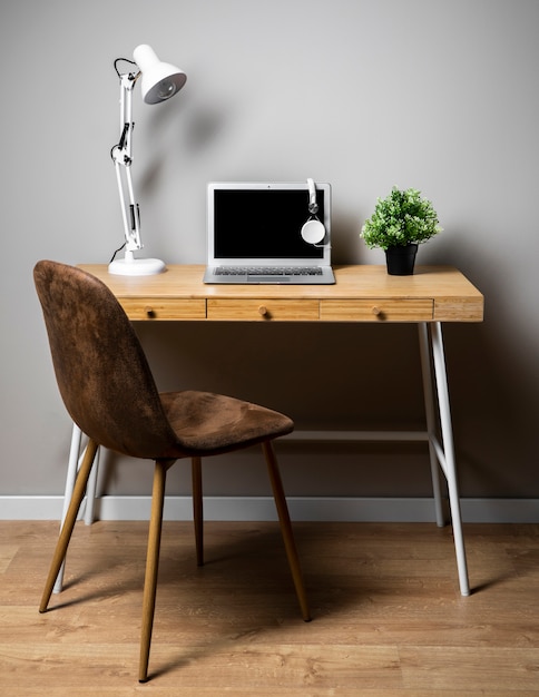 Бесплатное фото Стол с серым ноутбуком и лампой