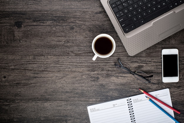 Desk with a laptop, a cup of coffee and a calendar