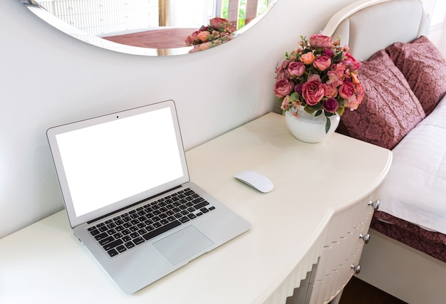 Desk with laptop and flowers