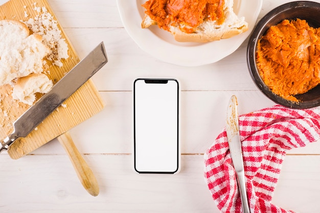 Desktop with mobile and sandwich and cooking towel