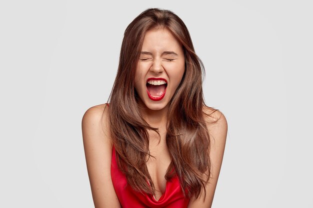 Desperate brunette young woman posing against the white wall