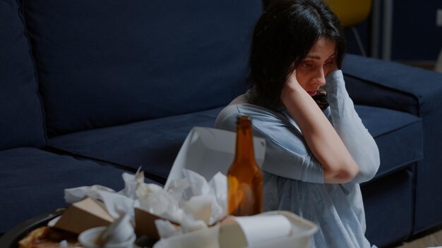 Desperate sad hopeless woman sitting alone on floor swaying having suicide thoughts chronic disease feeling depressed, upset stressed. Female suffering from anxiety, loneliness mental health problem