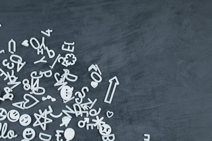 Free Photo detachable white color letters, icons and pins on black surface