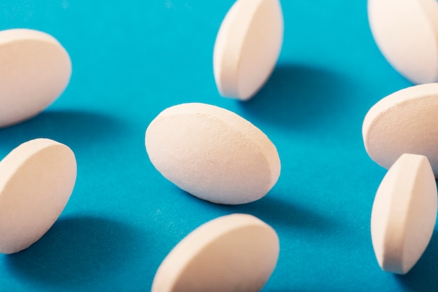 Detail of white round pills on blue background