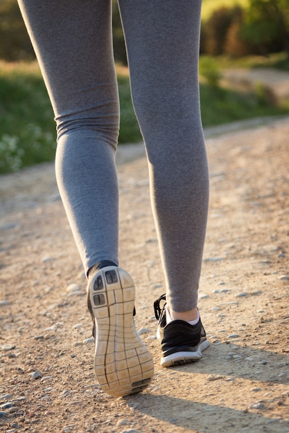 Dettaglio delle gambe donna che camminano sul campo