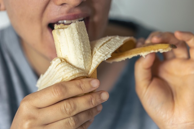 Foto gratuita foto dettagliata di una donna che mangia una banana fresca matura