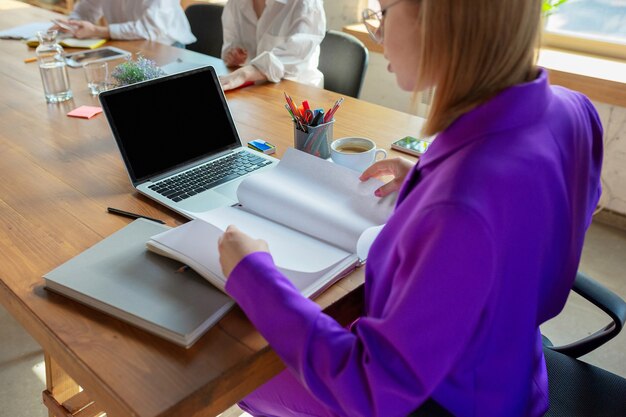 Detailes. Young caucasian business woman in modern office with team.