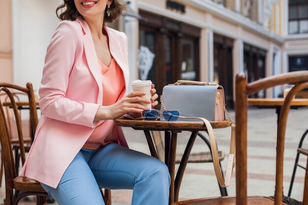 Details of accessories of pretty woman in stylish outfit sitting in cafe, sunglasses, handbag, pink and blue colors, spring summer fashion trend, elegant style, romatic mood, vacation in europe,