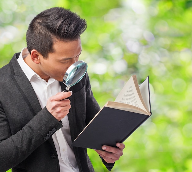 Detective reading a book with a magnifying glass