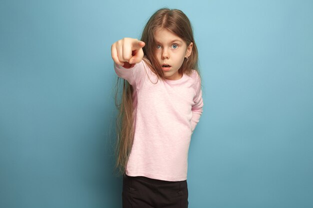 The determination. Teen girl on a blue background. Facial expressions and people emotions concept