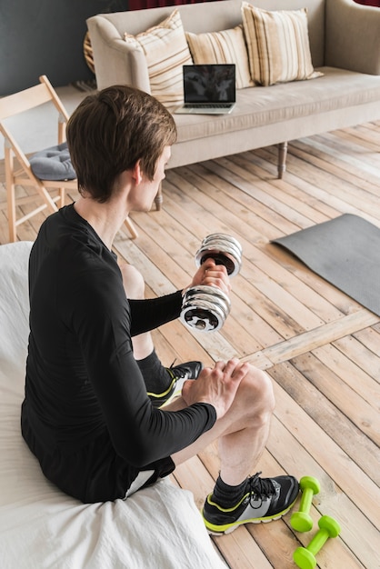 Determined male exercising with dumbbell