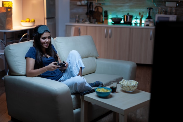 Determined woman playing video game in living room at night