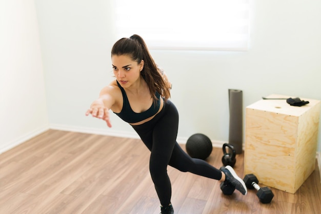 Free photo determined woman training to have a healthy and slim body. beautiful woman doing lateral bounds for her daily cardio and hiit workout