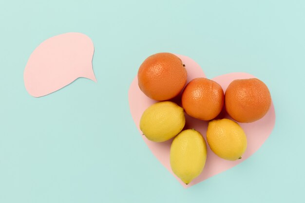 Детокс супер-выбор продуктов питания из свежих фруктов в бумажном сердце на синем фоне. Здоровое питание. Концептуальная композиция с copyspace