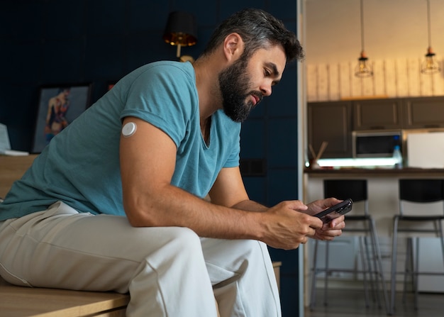 Free photo diabetic man checking glucose patch sensor