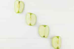 Free photo diagonal of apples slices on white background