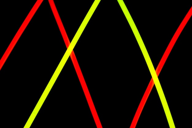 Foto gratuita le linee al neon rosse e gialle diagonali progettano su fondo nero