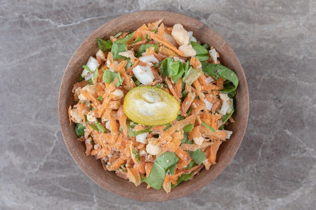 Diced carrots and vegetable salad in wooden bowl.