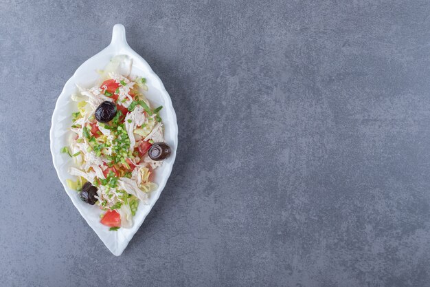 Free photo diced chicken salad on leaf-shaped plate.