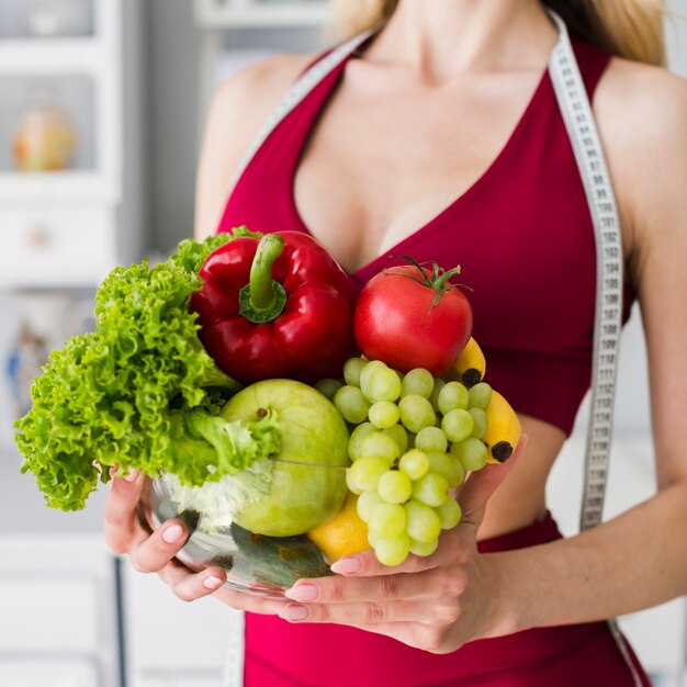 Diet concept with sporty woman in kitchen