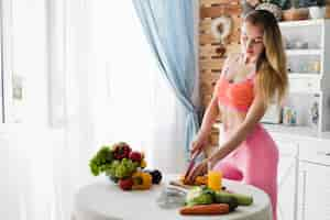 Free photo diet concept with sporty woman in kitchen