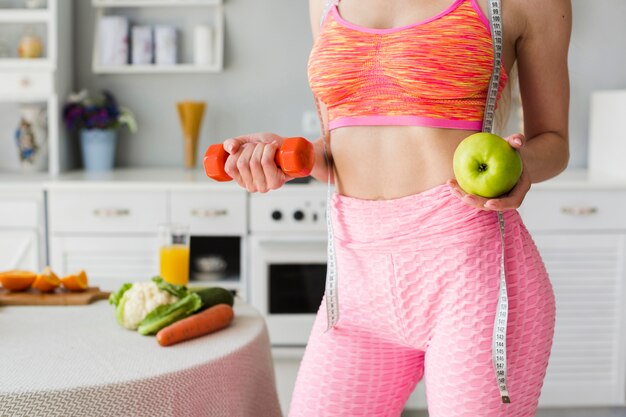 Diet concept with sporty woman in kitchen