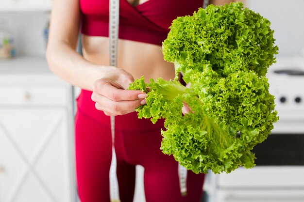 Diet concept with sporty woman in kitchen