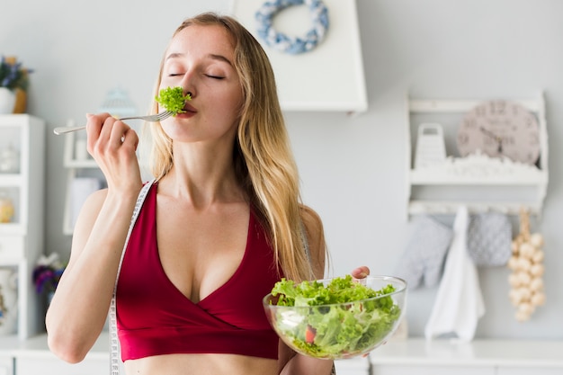 Diet concept with sporty woman in kitchen