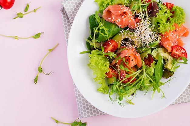 다이어트 메뉴. 신선한 야채-토마토, 아보카도, arugula, 씨앗 및 그릇에 연어의 건강 샐러드. 비건 음식. 평평하다. 평면도